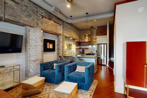 una cucina con due sedie blu e un muro di mattoni di 563 King Apartments a Charleston