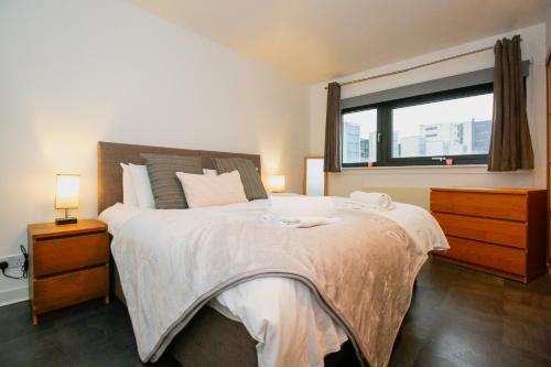 een slaapkamer met een groot bed en een raam bij Hydro Apartments in Glasgow