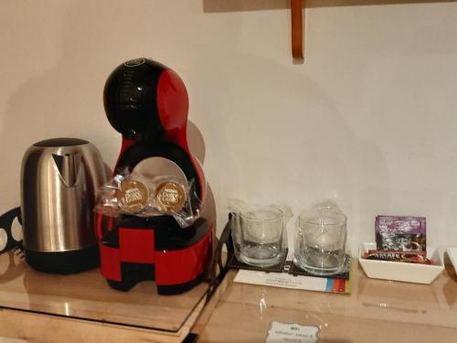 a counter top with a coffee maker and glasses at Hotel Tehuelche Natura in Coihaique