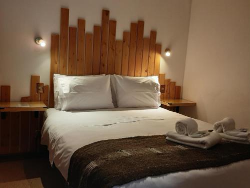 Dos muñecas en una cama en un dormitorio en Hotel Tehuelche Natura, en Coyhaique