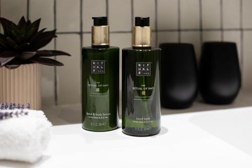 two green bottles of soap sitting on a counter at The Level at Melia White House in London