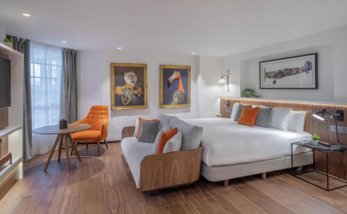 - une chambre avec un grand lit blanc et un canapé dans l'établissement The Level at Melia White House, à Londres