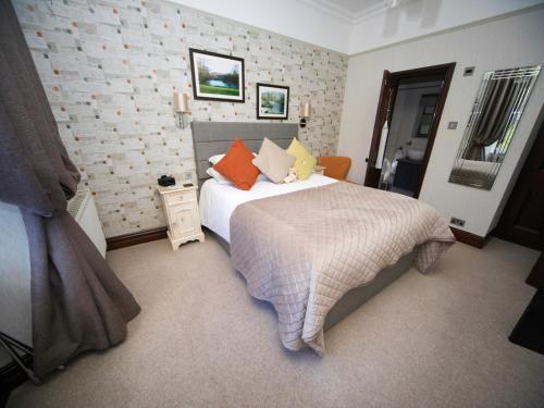 a bedroom with a large bed with pillows on it at Glenville House - Adults Only - Incl FREE off-site health club with swimming pool, hot tub, sauna & steam room in Windermere