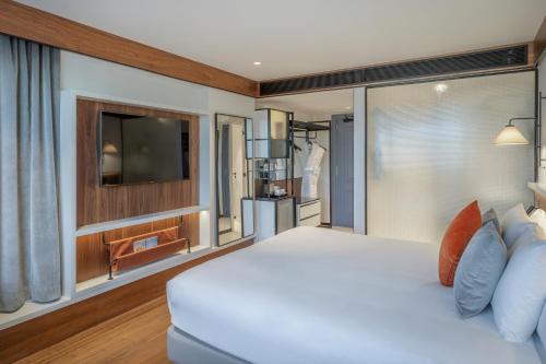 a bedroom with a white bed and a flat screen tv at The Level at Melia White House in London
