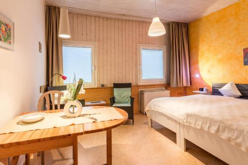 een slaapkamer met een bed, een bureau en een tafel bij Ferienwohnung Faden in Konstanz