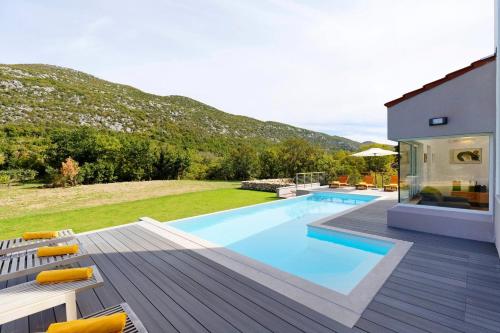 a villa with a swimming pool and a house at Villa Jure with upscale furnishings and a great garden, quiet location in Župa