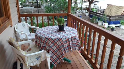 a table and chairs on a porch with a plant on it at Caunos bungalow in Muğla