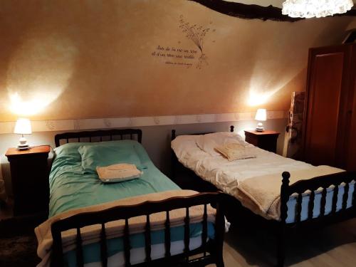 2 camas individuales en un dormitorio con 2 lámparas en la picarde, en Tours-en-Vimeu