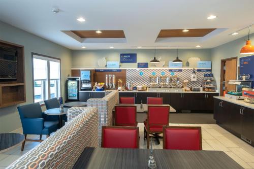a restaurant with tables and chairs and a counter at Holiday Inn Express & Suites Iron Mountain by IHG in Iron Mountain