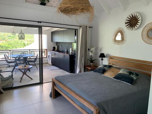 a bedroom with a bed and a kitchen and a table at CENTRAL PALM in Saint Barthelemy