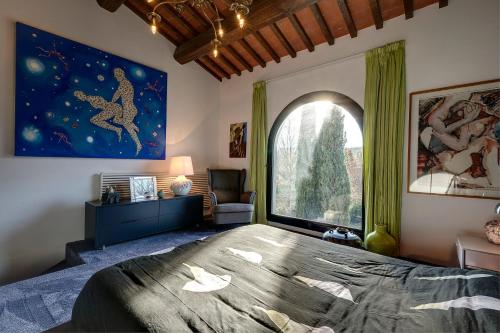 a bedroom with a large bed and a large window at LE MASSE - LOFT in Montelupo Fiorentino
