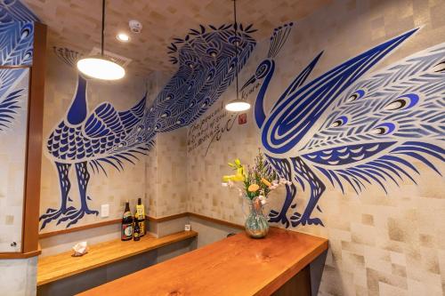a room with a table with a vase of flowers on the wall at Seiki Kyoto Station in Kyoto