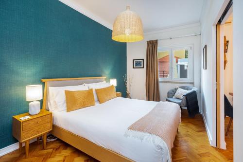 a bedroom with a large bed and a green wall at WHome | Estrela Family Apartment perfect for Families & Friends in Lisbon