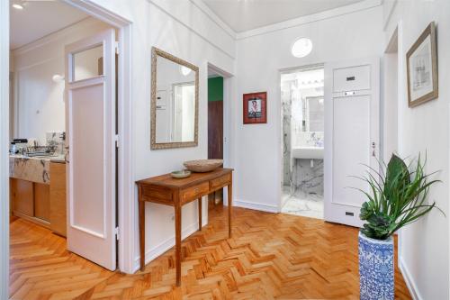 una cucina con pareti bianche, tavolo in legno e specchio di WHome | Estrela Family Apartment perfect for Families & Friends a Lisbona