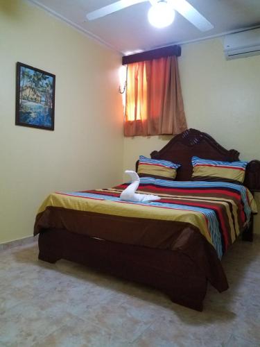 a bedroom with a large bed with a white bird on it at Hotel Victoriano in San Felipe de Puerto Plata