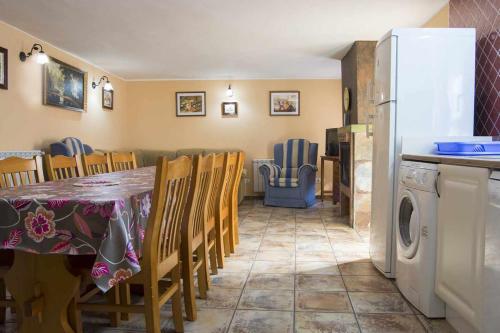 a kitchen with a table and chairs and a refrigerator at Casa rural con jacuzzi in La Parrilla