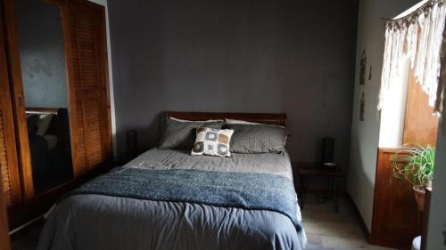 Una cama en un dormitorio con una almohada. en Casa Volta do Mar, en Horta