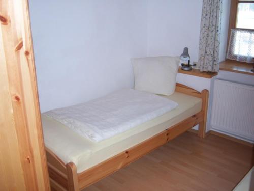 ein kleines Bett in einem Zimmer mit Fenster in der Unterkunft Irgenbauer in Chieming