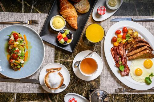 a table with plates of breakfast foods and a cup of coffee at The Hazelton Hotel in Toronto