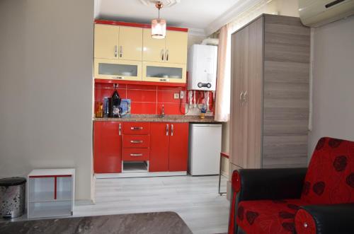 a kitchen with red cabinets and a red chair at TABRİZ HOTEL in Istanbul
