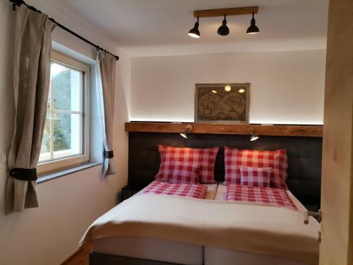 um quarto com uma cama com almofadas vermelhas e brancas em Ferienhaus Weber-Häusl em Reith im Alpbachtal