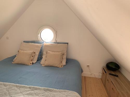 Un dormitorio con una cama con ventana. en Chalet TOUSVENTS, en Saint-Georges-de-Didonne
