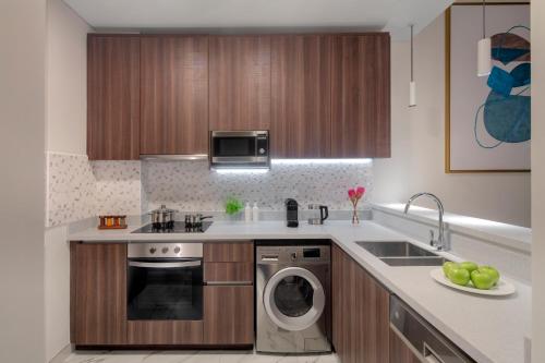 a kitchen with a sink and a dishwasher at Avani Plus Palm View Dubai Hotel & Suites in Dubai