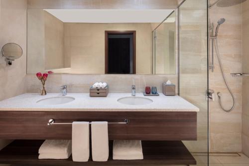 a bathroom with two sinks and a shower at Avani Plus Palm View Dubai Hotel & Suites in Dubai