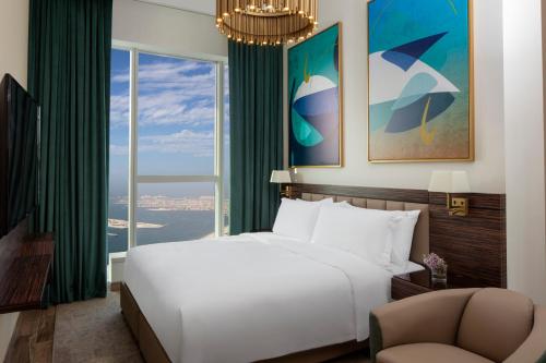 a bedroom with a large bed and a large window at Avani Plus Palm View Dubai Hotel & Suites in Dubai
