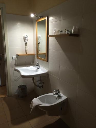 a bathroom with a sink and a mirror at Hotel Concordia in Porlezza