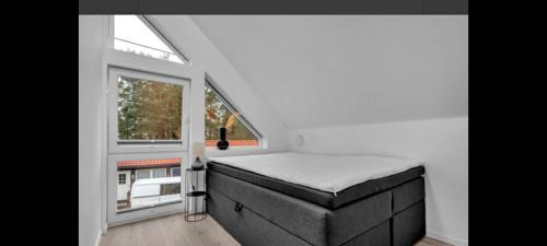 um pequeno quarto com uma cama e uma janela em Hytte med 4 Soverom em Kristiansand