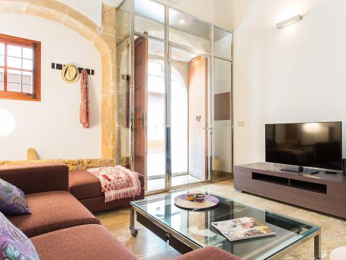 a living room with a couch and a tv at Town House Esglesia in Alcudia in Alcudia