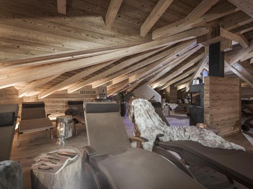 a room with wooden ceilings and chairs in a building at Aparthotel Stacherhof in Fügen