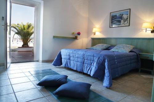 una camera da letto con letto e cuscini sul pavimento di Vel Marì - Rooms on the Beach ad Alghero