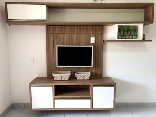 a entertainment center with a flat screen tv on a wall at Apto Novo no melhor d Pipa in Pipa