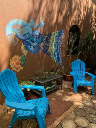 two blue chairs and a table in front of a building at The Garden Apartment at The Hacienda in Boquete