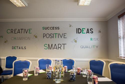 a conference room with a table and blue chairs at Holiday Inn Manchester West by IHG in Manchester
