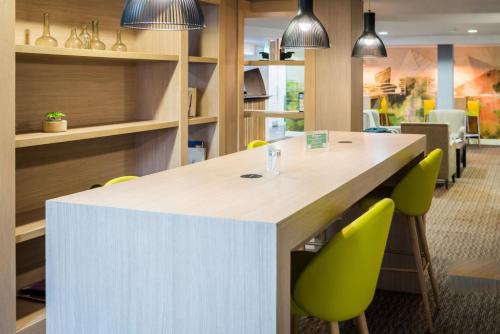 an office with a large table and green chairs at Holiday Inn Manchester West by IHG in Manchester