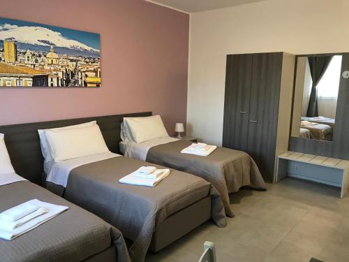 Habitación de hotel con 2 camas y espejo en Borgo Palombaio Home, en Catania