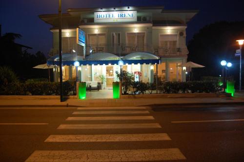 a building with a building with a lit up sign at Hotel Irene in Lignano Sabbiadoro