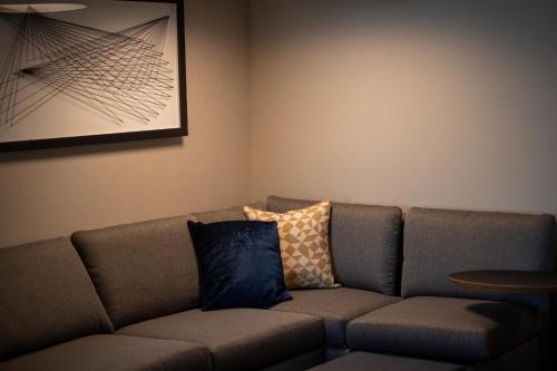 a living room with a couch with pillows on it at Hyatt Place Altoona/Des Moines in Altoona
