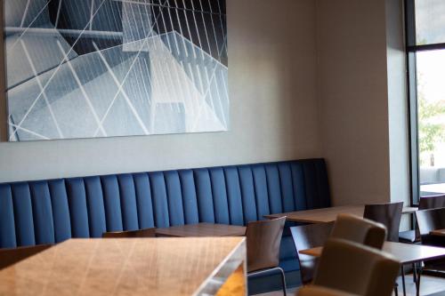 a dining room with wooden tables and chairs at Hyatt Place Altoona/Des Moines in Altoona