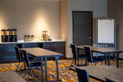 a room with tables and chairs and a bar at Hyatt Place Altoona/Des Moines in Altoona