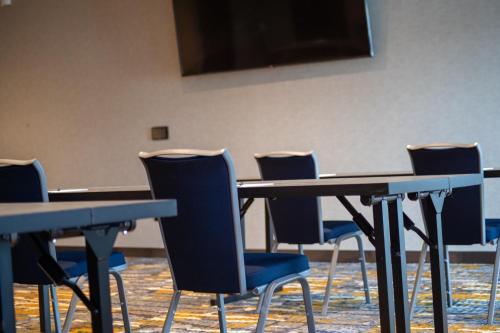 a group of tables and chairs in a room at Hyatt Place Altoona/Des Moines in Altoona