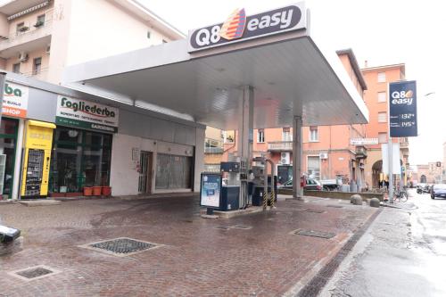a building with a gas station on a city street at Sun Bologna in Bologna