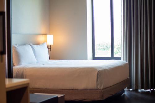 a bed in a hotel room with a window at Hyatt Place Altoona/Des Moines in Altoona