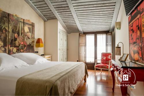 Un dormitorio con una cama, una mesa y una silla. en YIT La Casona del Arco, en Baeza