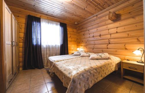 um quarto com uma cama num chalé de madeira em Jämsän Lomamökit em Jämsä