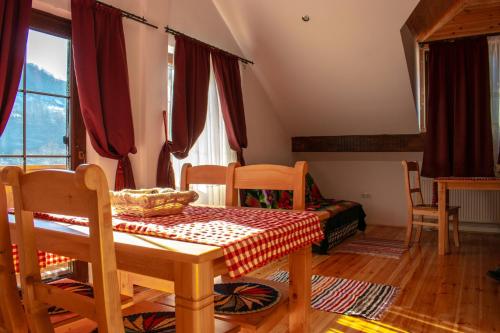 a dining room with a table and chairs and a room withwindows at Pensiune agroturistica Casa cu Povesti Rau Sadului in Rau Sadului
