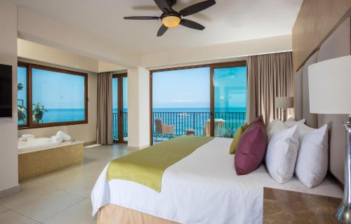 a bedroom with a bed with a view of the ocean at Almar Resort Luxury LGBT Beach Front Experience in Puerto Vallarta